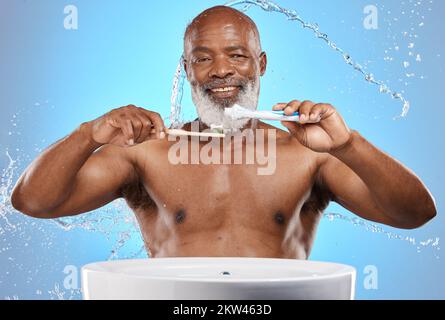 Denti spazzolanti, bambù e uomo nero in studio con dentifricio per la cura dei denti o della bocca promozione prodotto su mockup blu. Ritratto uomo nero senior Foto Stock