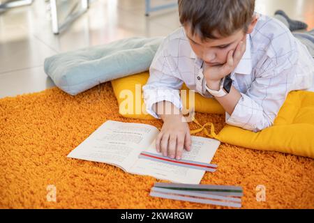 Khabarovsk, Russia, 28 ottobre 2022. Bambino dislessico lettura libro dislessia striscia righello colore Foto Stock