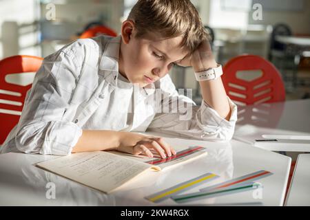 Khabarovsk, Russia, 28 ottobre 2022. Bambino dislessico lettura libro dislessia striscia righello colore Foto Stock