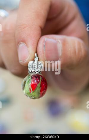 Pendente a forma di sfera con petalo di fiori all'interno in resina Foto Stock