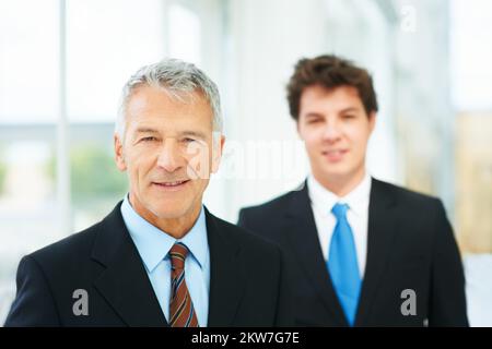 Portandoli a grande successo. Ritratto di due uomini d'affari di successo in piedi nella lobby di un edificio di uffici. Foto Stock