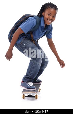 Mostrare le sue abilità pazza. Un giovane ragazzo afroamericano che fa un trucco sul suo skateboard. Foto Stock