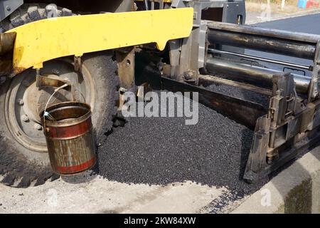 Finitrici, finitrici per asfalto o macchine per pavimentazione che posizionano uno strato di asfalto. Risalvataggio. Foto Stock