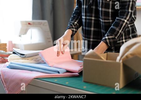 donna negozio online piccolo imprenditore imprenditore imprenditore venditore proprietario imballaggio pacchetto posta spedizione scatola. Donna sarto o dresssaker preparazione consegna pacco o Foto Stock