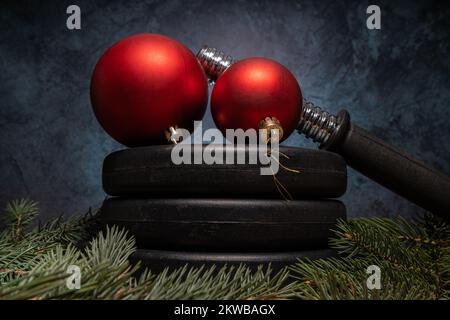 Piatti di peso di manubri, decorazioni baubles di Natale, rami di albero. Fitness stagione estiva composizione invernale. Allenamento in palestra. Foto Stock