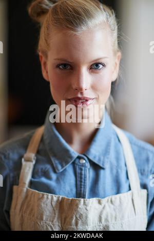 SA come preparare la migliore tazza di caffè. Una giovane donna che indossa un grembiule. Foto Stock