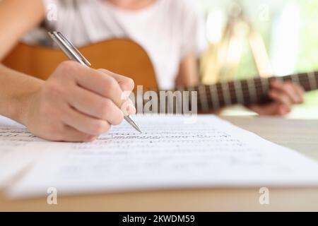 Primo piano di una compositrice femminile che scrive note musicali in quaderno. Foto Stock