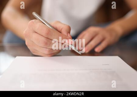 La donna firma un contratto o un accordo in primo piano. Foto Stock