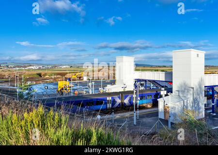 Inverness Airport Railway Station un treno Scotrail che si trova alla nuova stazione e all'aeroporto in lontananza Foto Stock