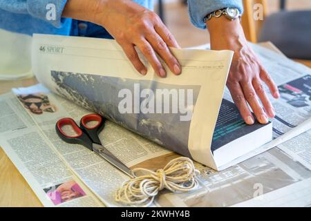 Confezione regalo sostenibile, su giornale, senza nastro adesivo, solo legato con cordino, Foto Stock