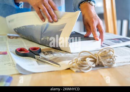 Confezione regalo sostenibile, su giornale, senza nastro adesivo, solo legato con cordino, Foto Stock