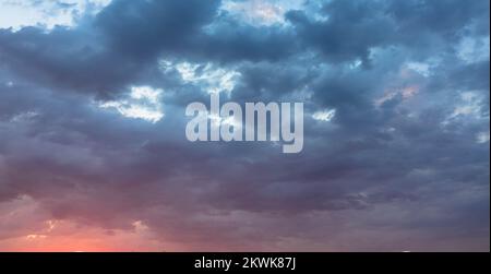 Spettacolare cielo crepuscolo e sfondo nuvoloso. Cielo naturale viola scuro. Nuvole scure, tempesta e pioggia. Concetto di clima e natura. Molto spazio di testo. Foto Stock