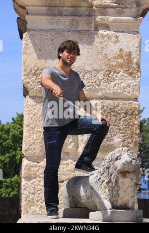 14.06.2013: Pola, Croazia. Stjepan Hauser, membro della band celista 2Cellos in anfiteatro fotografato con il soldato romano. 2Cellos si esibirà in Arena il 7th luglio. Foto: Dusko Marusic/PIXSELL Foto Stock