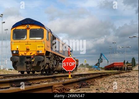 Locomotiva diesel di classe 66 in GB Railload vagoni di zavorra per trasporto di livrea sulla ferrovia del Regno Unito, Inghilterra. Foto Stock