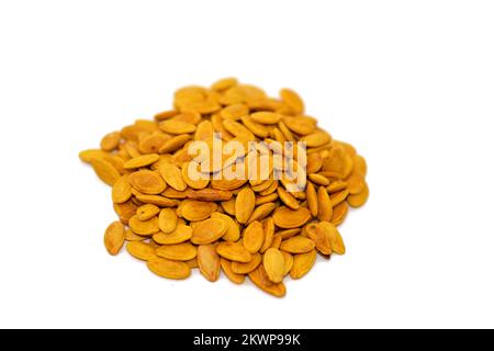 Cumulo di semi di cocomero di Citrullus lanatus, salato, tostati e non pelati, grani isolati su fondo bianco, fuoco selettivo di semi di cocomero secco marrone t Foto Stock