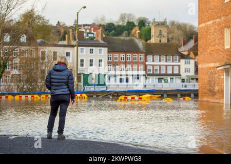 Bewdley, Regno Unito. 23rd febbraio, 2022. Vista posteriore di una donna che guarda fuori sul fiume alluvionale a Beale's Corner a Bewdley, mentre il fiume Severn esplode le sue rive, ancora una volta, in questa cittadina rurale del Worcestershire. Credit Lee Hudson Foto Stock