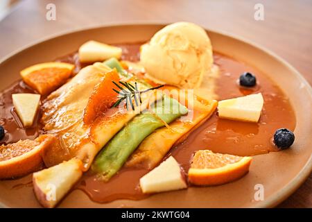 Crepes con gelato alla vaniglia, salsa d'arancia e arance fresche Foto Stock