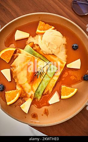Crepes con gelato alla vaniglia, salsa d'arancia e arance fresche Foto Stock