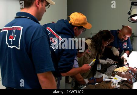 Hurricane Wilma, Belle Glade, FL, 26 ottobre 2005 i membri del team di assistenza medica di emergenza di FEMA, Oklahoma One, assistono il personale del Glades General Hospital esaminare ad un paziente nel pronto soccorso. L'uragano Wilma, il quinto grande uragano della stagione, è venuto attraverso questa zona. Fotografie relative a disastri e programmi, attività e funzionari di gestione delle emergenze Foto Stock