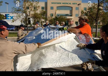 Hurricane Wilma, Plantation, FL, 27 ottobre 2005 i membri del team di assistenza medica per le catastrofi FEMA hanno creato tende che saranno utilizzate come base per le operazioni di visita dei pazienti al Westside Regional Medical Center. Il team DMAT è qui per aiutare l'aumento dei pazienti al pronto soccorso a causa dell'uragano Wilma. Fotografie relative a disastri e programmi, attività e funzionari di gestione delle emergenze Foto Stock