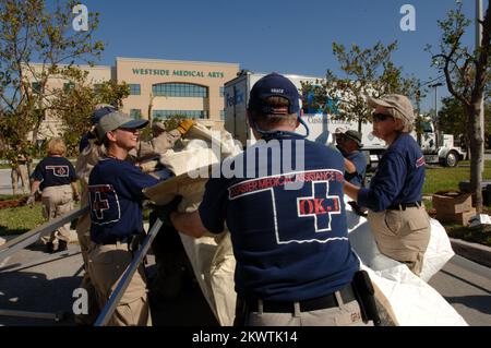 Plantation, FL, 27 ottobre 2005- i membri del team di assistenza medica per le catastrofi FEMA hanno creato tende che saranno utilizzate come base per le operazioni di visita dei pazienti al Westside Regional Medical Center. Il team DMAT è qui per aiutare l'aumento dei pazienti al pronto soccorso a causa dell'uragano Wilma. Fotografie relative a disastri e programmi, attività e funzionari di gestione delle emergenze Foto Stock