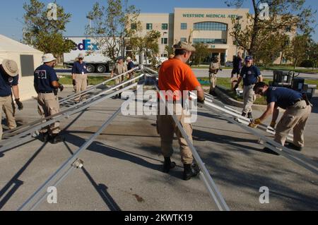 Hurricane Wilma, Plantation, FL, 27 ottobre 2005 i membri del team di assistenza medica per le catastrofi FEMA hanno creato tende che saranno utilizzate come base per le operazioni di visita dei pazienti al Westside Regional Medical Center. Il team DMAT è qui per aiutare l'aumento dei pazienti al pronto soccorso a causa dell'uragano Wilma. Fotografie relative a disastri e programmi, attività e funzionari di gestione delle emergenze Foto Stock