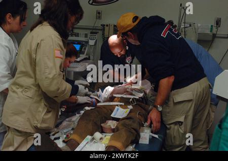 Hurricane Wilma, Belle Glade, FL, 26 ottobre 2005 i membri del team di assistenza medica di emergenza di FEMA, Oklahoma One, assistono il personale del Glades General Hospital esaminare un paziente nel pronto soccorso. L'uragano Wilma, il quinto grande uragano della stagione, è venuto attraverso questa zona. Fotografie relative a disastri e programmi, attività e funzionari di gestione delle emergenze Foto Stock