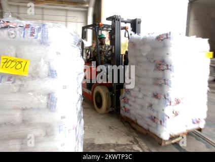 Hurricane Wilma, Homestead, FL, 30 ottobre 2005 i guardiani nazionali spostano pallet di ghiaccio in un appendiabiti presso la base dell'aeronautica che viene utilizzata come area di sosta per la distribuzione di acqua e ghiaccio per le aree colpite dall'uragano Wilma. Jocelyn Augustno/FEMA.. Fotografie relative a disastri e programmi, attività e funzionari di gestione delle emergenze Foto Stock