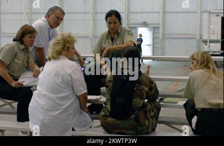 Hurricane Wilma, Homestead, FL, 30 ottobre 2005 i membri del team Incident Command discutono delle operazioni presso la base dell'aeronautica militare Homestead, che viene utilizzata come area di messa in scena delle operazioni per la distribuzione di acqua e ghiaccio nelle aree colpite dall'uragano Wilma. Jocelyn Augustno/FEMA.. Fotografie relative a disastri e programmi, attività e funzionari di gestione delle emergenze Foto Stock