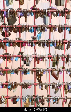 Molti lucchetti d'amore bloccati su un cancello di ferro arrugginito a singapore Foto Stock