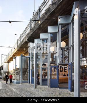 Facciata prospettiva con vasche di birra. Camden Town Beer Hall, Londra, Regno Unito. Architetto: Gundry & Ducker, 2021. Foto Stock