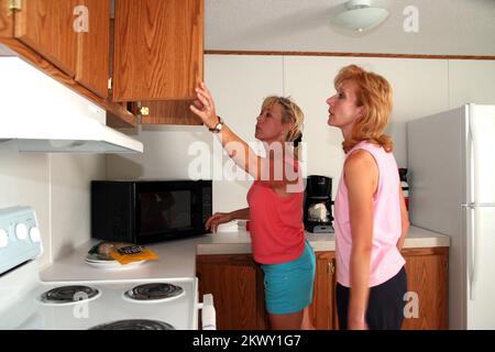 Gravi tempeste, tornado e alluvioni, Greensburg, KS, 27 maggio 2007 Patty Self e Amy Guyette guardare sopra la cucina in una casa mobile campione FEMA. Sono in corso piani per costruire un parco per i residenti di Greensburg mentre le loro case sono ricostruite. Fotografie relative a disastri e programmi, attività e funzionari di gestione delle emergenze Foto Stock