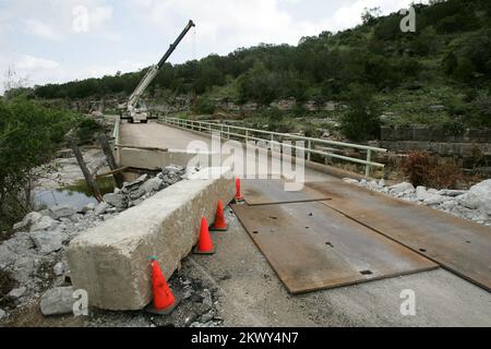 Gravi tempeste, tornado, e inondazioni, Marble Falls, Texas, Il 2 luglio 2007 i lavoratori pulisce i detriti da un torrente locale e lavorano su un ponte danneggiato dopo la pioggia record della scorsa settimana di 19 pollici in una notte. Bob McMillan/ FEMA Foto.. Fotografie relative a disastri e programmi, attività e funzionari di gestione delle emergenze Foto Stock