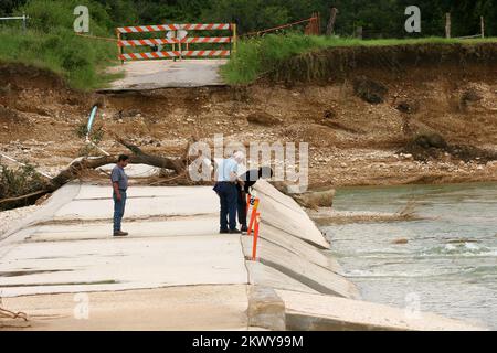 Gravi tempeste, tornado, ed allagando, Hondo, TX, 24 luglio 2007 lo specialista dell'assistenza pubblica della FEMA Sheila Luster insieme ai Commissari della contea di Medina Arturo Barrientes e Ronnie Ulbrich ispezionano i danni causati dalle inondazioni alle infrastrutture locali per determinare se la contea sarà idonea all'assistenza federale in caso di calamità. Bob McMillan/ FEMA Foto.. Fotografie relative a disastri e programmi, attività e funzionari di gestione delle emergenze Foto Stock