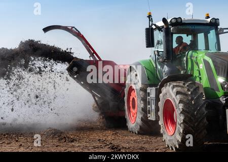 Girando un mucchio di concime sopra fare composto per spargere su terreno agricolo, che aiuta ad aumentare la qualità del suolo. North Yorkshire, Regno Unito. Foto Stock