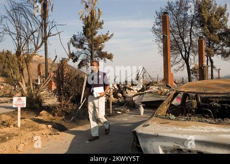 Incendi boschivi, Rancho Bernardo, CA, 28 ottobre 2007 Uno specialista delle relazioni con la comunità FEMA cammina nel quartiere di Rancho Bernardo distribuendo informazioni sui disastri alle vittime di incendi boschivi. Andrea Booher/FEMA.. Fotografie relative a disastri e programmi, attività e funzionari di gestione delle emergenze Foto Stock