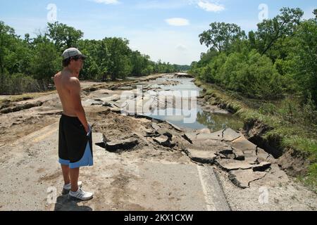 Gravi tempeste, tornado, e inondazioni, Linn County, IA, 19 giugno 2008 il residente locale Austin Plante si affaccia sulla sezione slavata di Lewis Bottom Road, distrutta una settimana fa dall'alluvione del fiume Cedar. Questa era una delle strade principali per la città di Palo, dove ogni edificio subì danni da alluvioni. Fotografie relative a disastri e programmi, attività e funzionari di gestione delle emergenze Foto Stock