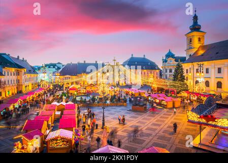 Sibiu, Romania - Dicembre 2014: Immagine notturna con i turisti al mercato di Natale di Sibiu in Piazza Grande, centro medievale della Transilvania. Foto Stock