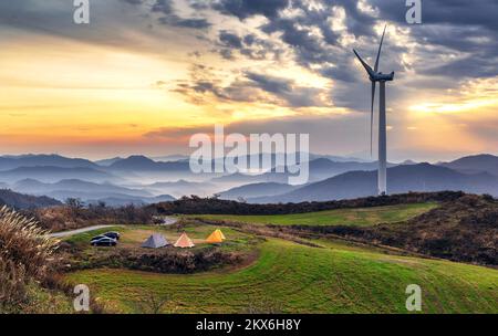 Campeggio e l'alba con vista sui mulini a vento dalla cima della montagna Foto Stock