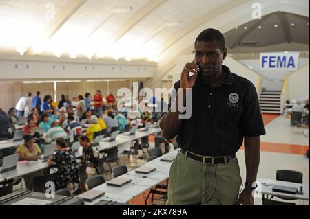 Terremoto tsunami - Utulei, Samoa Americane, 9 ottobre 2009 il coordinatore federale Kenneth Tingman prende un appello sulle operazioni di recupero. Tingman stava visitando il Centro di recupero di emergenza di FEMA il secondo giorno delle operazioni mentre il centro ha servito i sopravvissuti dal villaggio di Pago Pago. DaN Stoneking/FEMA. Terremoto delle Samoa Americane, tsunami ed alluvioni. Fotografie relative a disastri e programmi, attività e funzionari di gestione delle emergenze Foto Stock