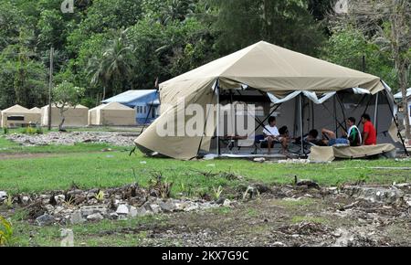 Terremoto alluvione Tsunami - Amanave, Samoa Americane, 15 novembre 2009 grandi, forti nuove tende sono state ben accolte in Amanave, che è stato il primo luogo a ricevere le 16-per-16 piedi tende progettate per resistere alle condizioni stagionali ventose e piovose ora prevalenti nelle Samoa Americane. Sostituirono tende più piccole, a cupola. I destinatari hanno lodato la flessibilità delle nuove tende. Le pareti possono essere sollevate o abbassate secondo necessità. Il può essere chiuso per motivi di privacy. All'interno, restarono asciutti durante la pioggia torrenziale che iniziò diverse ore dopo che le tende furono erette. Richard o'Reilly/FEMA. American S Foto Stock