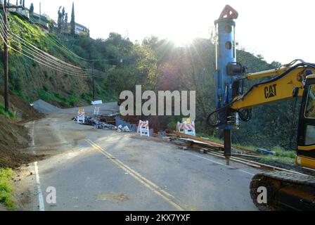 Tempesta invernale con frana e frana alluvione - Los Angeles, California. , Il 11 marzo 2010 LADOT ha chiuso una sezione di Mulholland Drive quando una porzione della carreggiata ha ceduto alla gravità a causa di un grande foro del dispersore erodente sotto la superficie causato da forti tempeste invernali. I macchinari pesanti sono stati spostati per riparare il danno e ripristinare la famosa strada tortuosa. Adam DuBrowa/FEMA. California gravi tempeste invernali, inondazioni, detriti e flussi di fango. Fotografie relative a disastri e programmi, attività e funzionari di gestione delle emergenze Foto Stock
