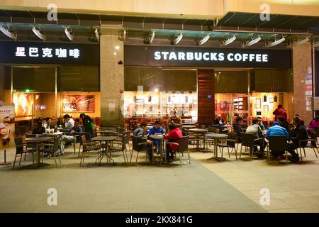 SHENZHEN, CINA - 22 GENNAIO 2015: Starbucks Cafe di notte. Starbucks Corporation è un'azienda americana globale di caffè e una catena di caffè con sede in Foto Stock