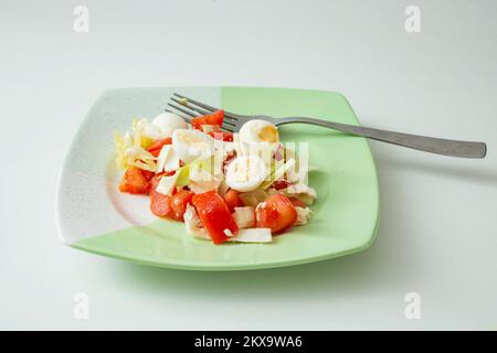 insalata di uova di quaglia su un piatto verde, vista laterale da vicino Foto Stock