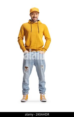 Ritratto completo di un giovane uomo con felpa con cappuccio gialla e jeans che posano con le mani in tasche isolate su sfondo bianco Foto Stock
