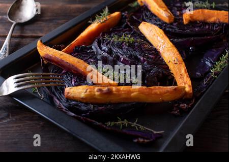 Cavolo rosso arrosto con patate dolci su una teglia da forno Delizioso contorno per cena o pranzo Foto Stock