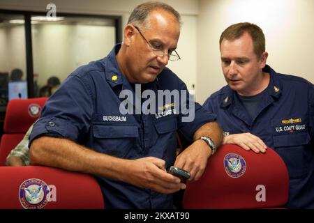 Uragano di allagamento/tempesta tropicale grave Storm - St. Thomas, Isole Vergini americane, 30 agosto 2010 supervisore della sicurezza marina della Guardia Costiera, LCDR Daniel Buchsbaum esamina un rapporto aggiornato sulla situazione di Earl uragano sul suo blackberry con il capo James Carew del tecnico della Guardia Costiera, responsabile della scienza marina, presso il Centro operativo per le emergenze della Virgin Islands Territorial Emergency Management Agency (VITEMA) di St Thomas. Andrea Booher/FEMA.. Fotografie relative a disastri e programmi, attività e funzionari di gestione delle emergenze Foto Stock