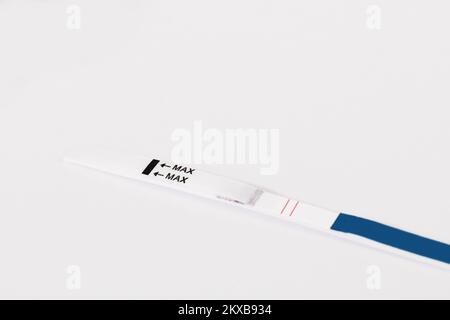 Test di gravidanza positivo isolato su sfondo bianco. Concetto di pianificazione della gravidanza. Foto Stock