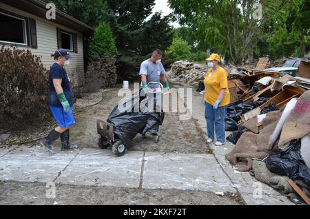 Inondazioni - Minot, N. D. , 18 luglio 2011 i volontari del Southern Baptist Convention Disaster Recovery Service aiutano i residenti a rimuovere i detriti da una casa danneggiata dalle inondazioni a Minot, North Dakota. I team di Baptist Disaster Response sono una delle molte organizzazioni di volontariato a Minot che aiutano a ripulire gli sforzi. Alluvione del North Dakota. Fotografie relative a disastri e programmi, attività e funzionari di gestione delle emergenze Foto Stock