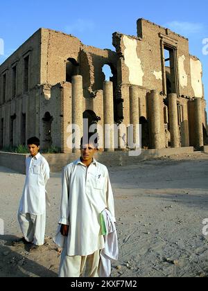 Jalalabad, Provincia di Nangarhar / Afghanistan: Due uomini in abbigliamento tradizionale si trovano di fronte alle rovine di Seraj-ul Emorat a Jalalabad, Afghanistan. Foto Stock